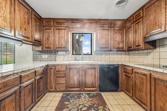 300 W 11th St, Wheeler, TX 79096 - kitchen with black dishwasher, a sink, backsplash, a textured ceiling, and light tile patterned floors