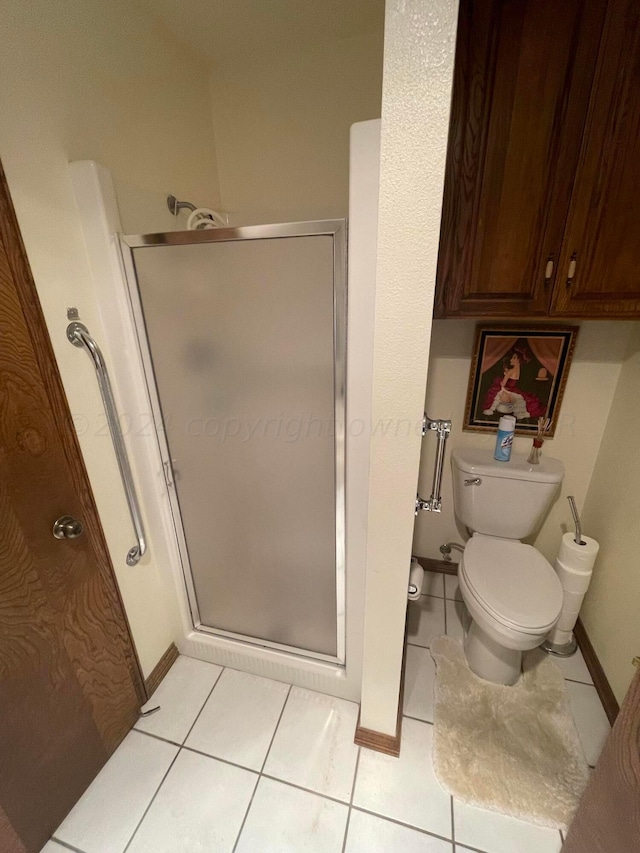 bathroom featuring tile patterned flooring, toilet, and walk in shower