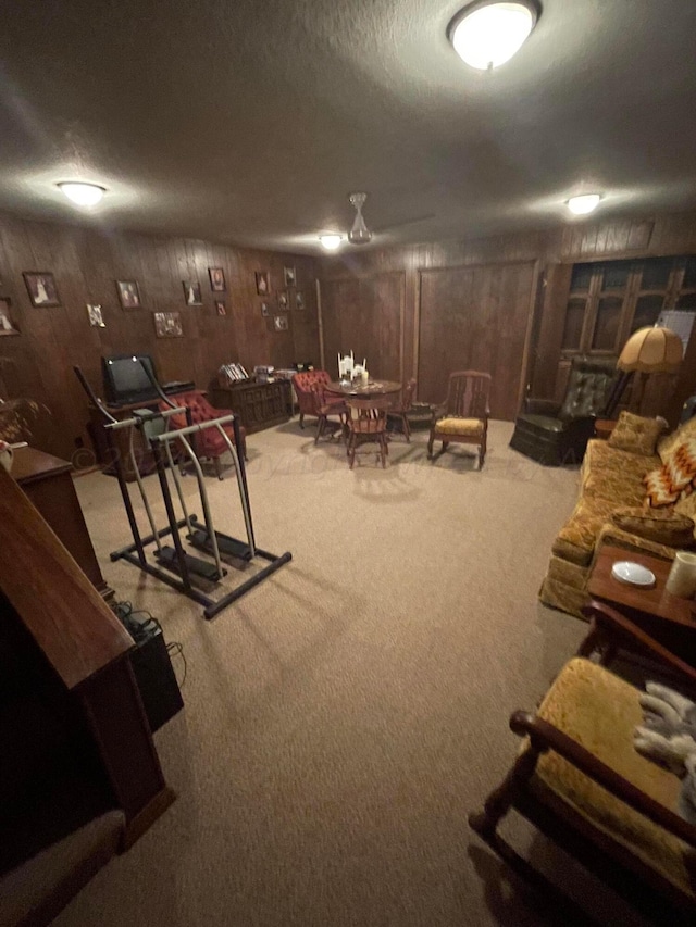 interior space with wood walls, light colored carpet, and a textured ceiling