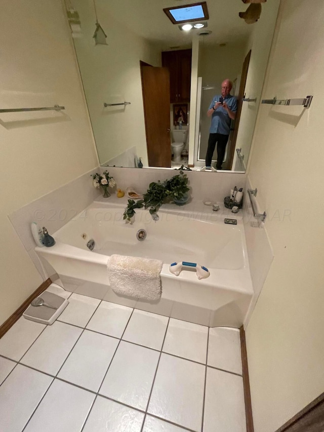 bathroom with tile patterned flooring, toilet, and a washtub