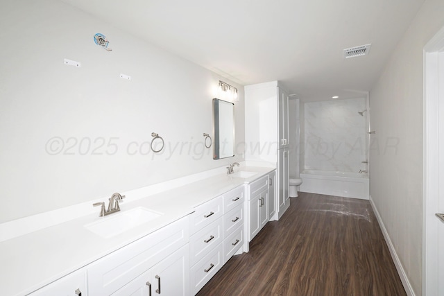 bathroom with double vanity, toilet, visible vents, and a sink