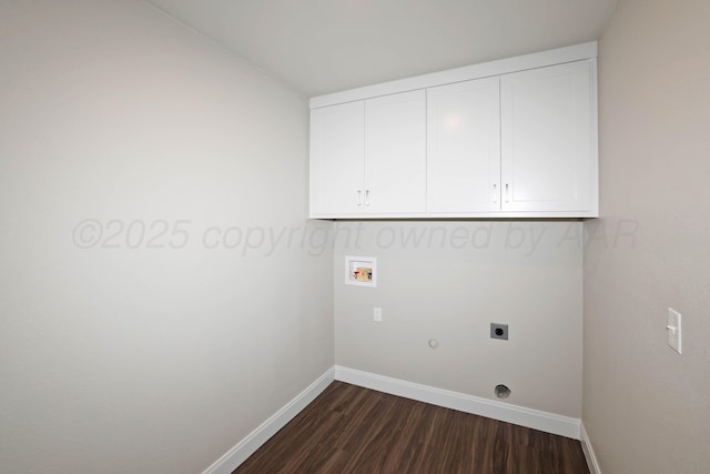 washroom featuring gas dryer hookup, hookup for an electric dryer, dark wood finished floors, cabinet space, and baseboards