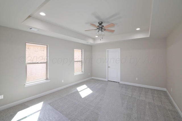 unfurnished room featuring a ceiling fan, light carpet, a tray ceiling, and recessed lighting