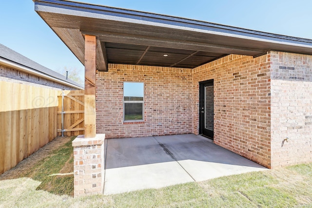 view of patio featuring fence and a gate