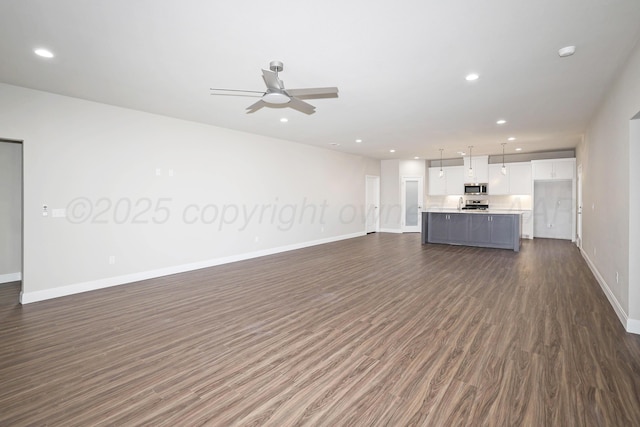 unfurnished living room featuring baseboards, recessed lighting, dark wood finished floors, and ceiling fan
