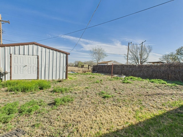 view of yard featuring a shed, an outbuilding, and fence