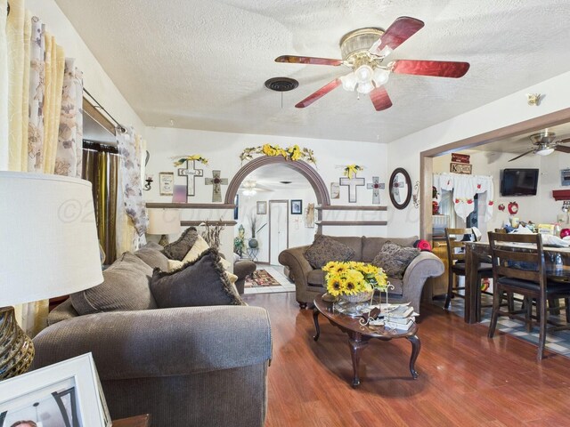 living area featuring a textured ceiling, ceiling fan, and wood finished floors