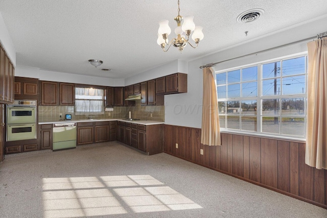 kitchen featuring visible vents, double wall oven, white dishwasher, a sink, and light countertops