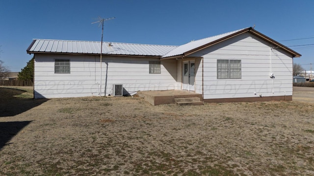 back of house with metal roof and cooling unit