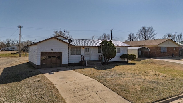 single story home featuring metal roof, concrete driveway, and an attached garage