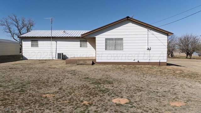 back of property featuring metal roof and central AC