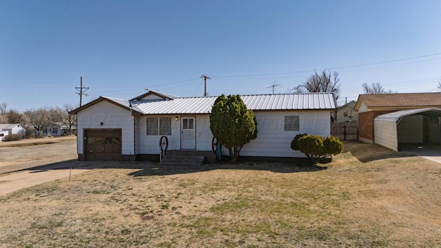 ranch-style house featuring a garage, metal roof, driveway, and fence