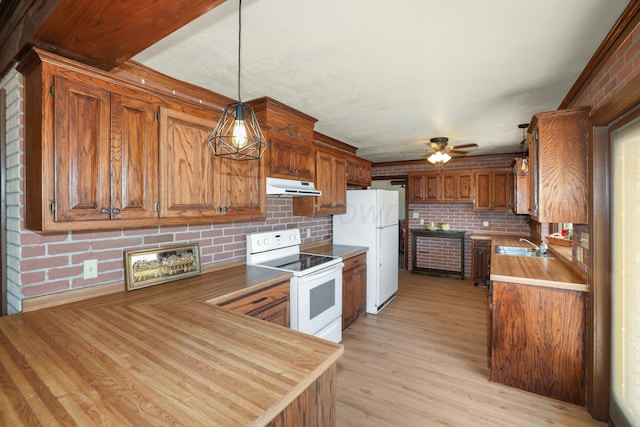 kitchen with tasteful backsplash, light wood-type flooring, white appliances, and decorative light fixtures