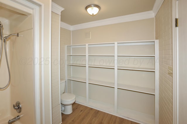 bathroom featuring hardwood / wood-style flooring, ornamental molding, and toilet