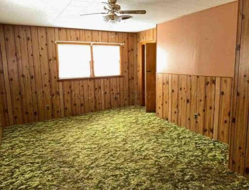 1035 N Duncan St, Pampa, TX 79065 - carpeted empty room with ceiling fan and wooden walls