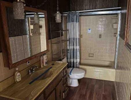 1035 N Duncan St, Pampa, TX 79065 - full bath with wood finished floors, shower / bath combo, vanity, and tile walls