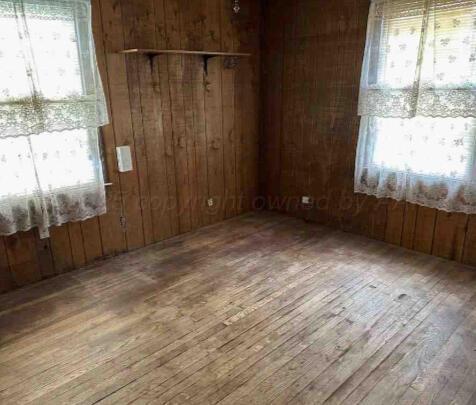 1035 N Duncan St, Pampa, TX 79065 - empty room featuring hardwood / wood-style floors and wooden walls