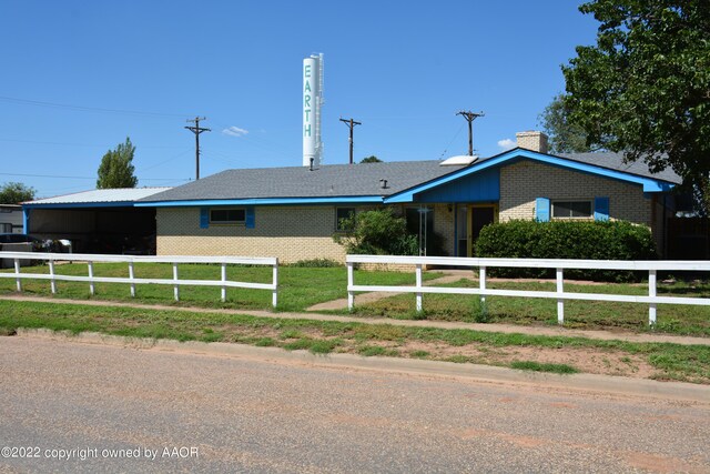 view of front of house featuring a fenced front yard, a carport, and brick siding