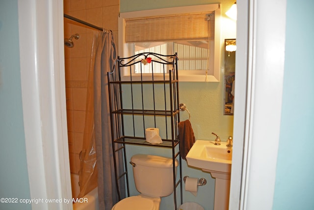 bathroom featuring toilet and shower / bath combo with shower curtain