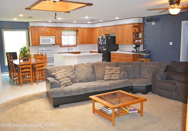 living room featuring ceiling fan and sink