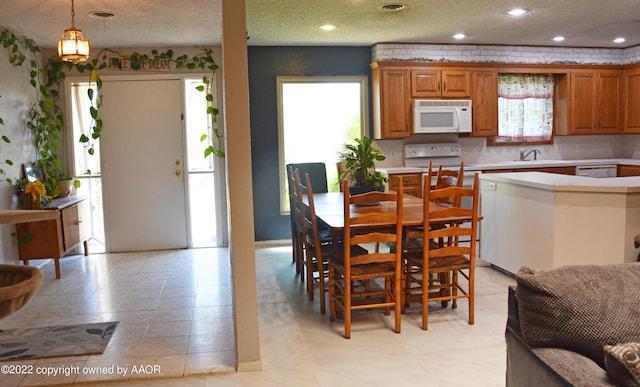 dining area featuring a textured ceiling, a wealth of natural light, and sink