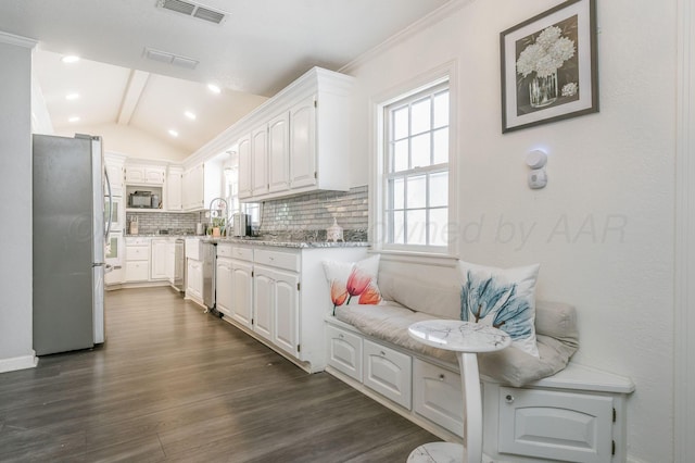 kitchen featuring white cabinets, appliances with stainless steel finishes, visible vents, and decorative backsplash