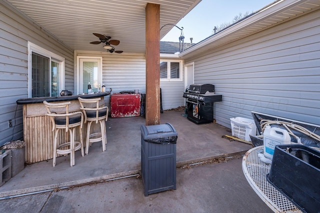 view of patio with outdoor dry bar, grilling area, and a ceiling fan