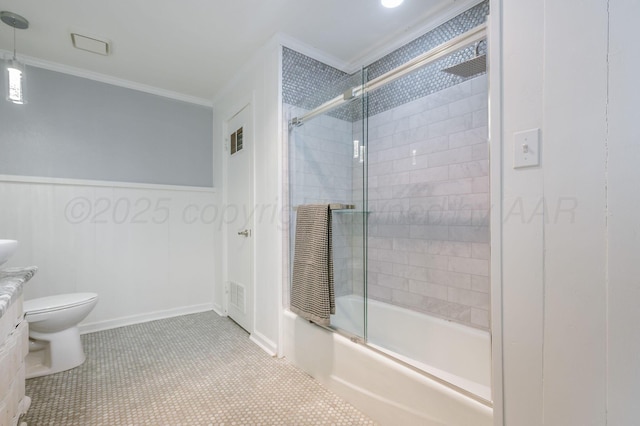 bathroom featuring crown molding, bath / shower combo with glass door, visible vents, toilet, and wainscoting