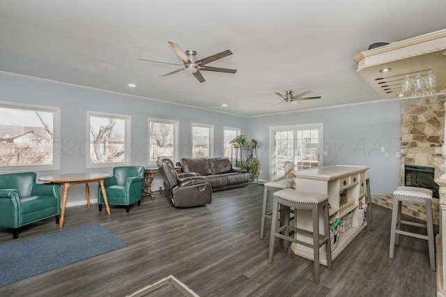 living area with dark wood-style flooring, a fireplace, crown molding, recessed lighting, and a ceiling fan