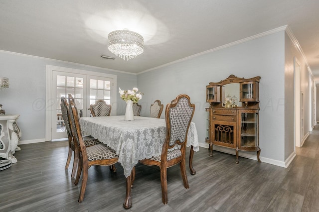 dining space featuring an inviting chandelier, baseboards, visible vents, and wood finished floors