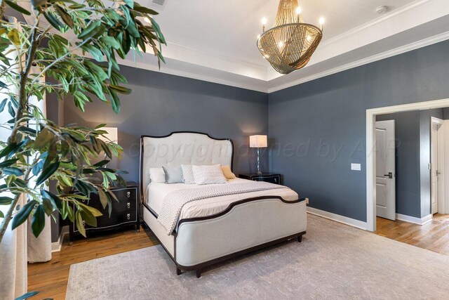 27 Carnoustie Ln, Amarillo, TX 79124 - bedroom with a chandelier, a tray ceiling, wood finished floors, and ornamental molding