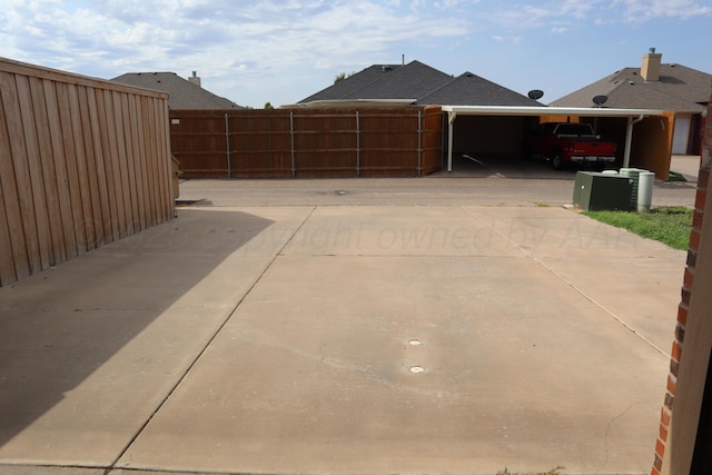 9807 Will Ave, Amarillo, TX 79119 - view of side of home featuring a carport and concrete driveway