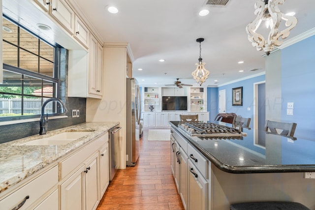3523 Rutson Dr, Amarillo, TX 79109 - kitchen with a sink, ornamental molding, stainless steel appliances, a chandelier, and open floor plan