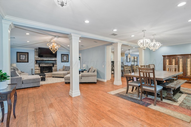 3523 Rutson Dr, Amarillo, TX 79109 - dining area featuring a stone fireplace, light wood-type flooring, ornate columns, recessed lighting, and a chandelier