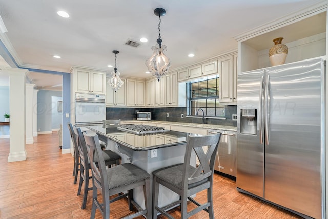 3523 Rutson Dr, Amarillo, TX 79109 - kitchen featuring appliances with stainless steel finishes, decorative backsplash, crown molding, a breakfast bar area, and recessed lighting