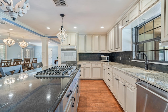 3523 Rutson Dr, Amarillo, TX 79109 - kitchen with a sink, appliances with stainless steel finishes, a chandelier, decorative light fixtures, and backsplash