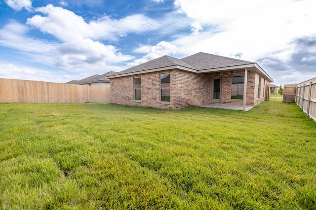 10502 Ruse St, Amarillo, TX 79118 - rear view of house featuring a patio, a fenced backyard, brick siding, and roof with shingles