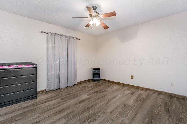 unfurnished bedroom with a textured ceiling, ceiling fan, and hardwood / wood-style flooring