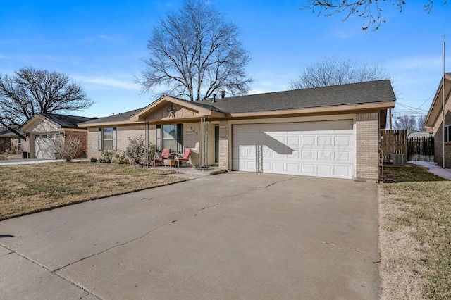 single story home featuring a garage, a front yard, and central AC unit