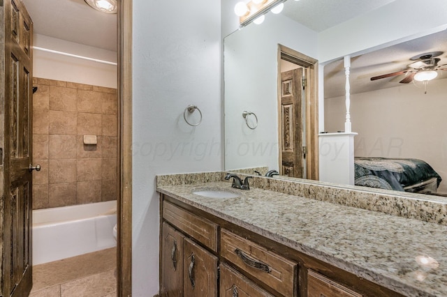 bathroom with ceiling fan, tiled shower / bath combo, and vanity