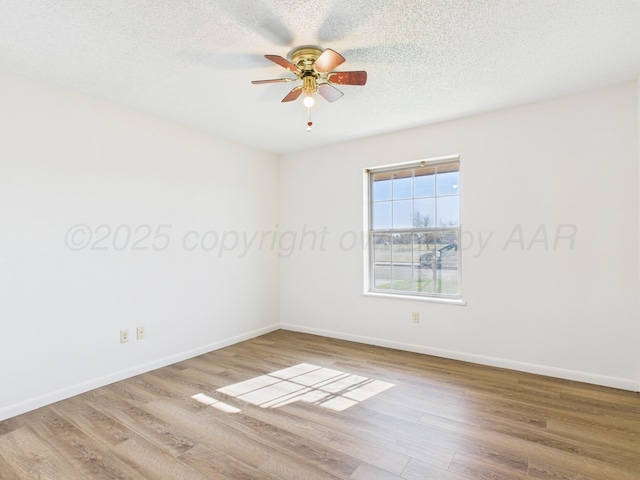 spare room with baseboards, a textured ceiling, a ceiling fan, and wood finished floors