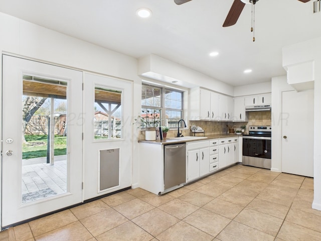 kitchen with white cabinets, a sink, appliances with stainless steel finishes, a ceiling fan, and decorative backsplash
