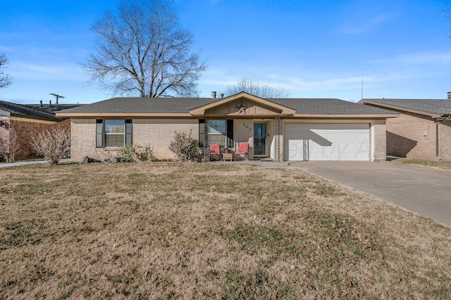 ranch-style home featuring a garage, brick siding, driveway, and a front lawn