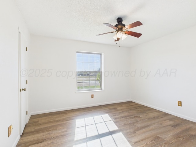 unfurnished room featuring a textured ceiling, wood finished floors, ceiling fan, and baseboards