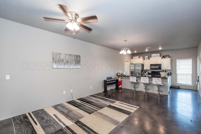kitchen with stainless steel refrigerator with ice dispenser, black microwave, a chandelier, a kitchen bar, and ceiling fan