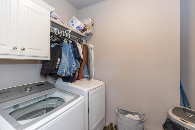 washroom featuring washing machine and clothes dryer and cabinet space