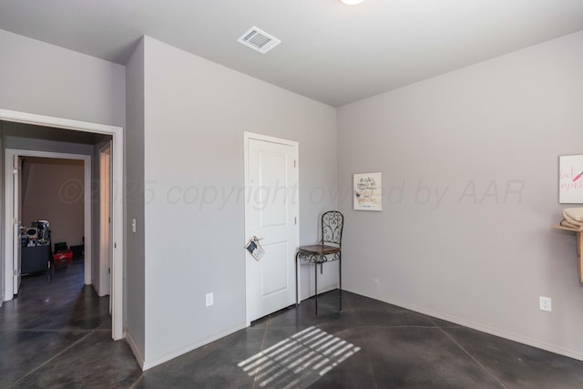 bedroom featuring concrete flooring and baseboards