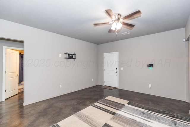 unfurnished room featuring finished concrete floors, ceiling fan, and baseboards