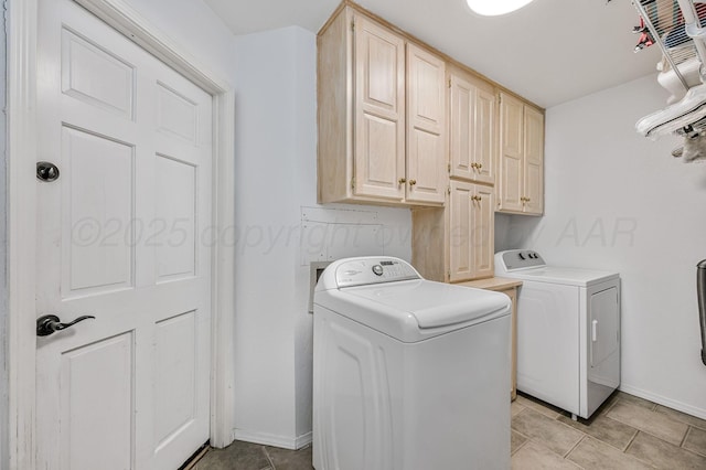 washroom with baseboards, cabinet space, and independent washer and dryer