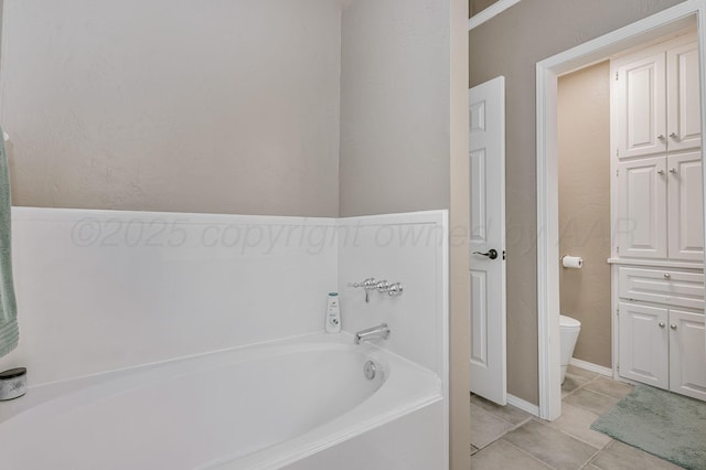 bathroom with a bath, tile patterned floors, and toilet